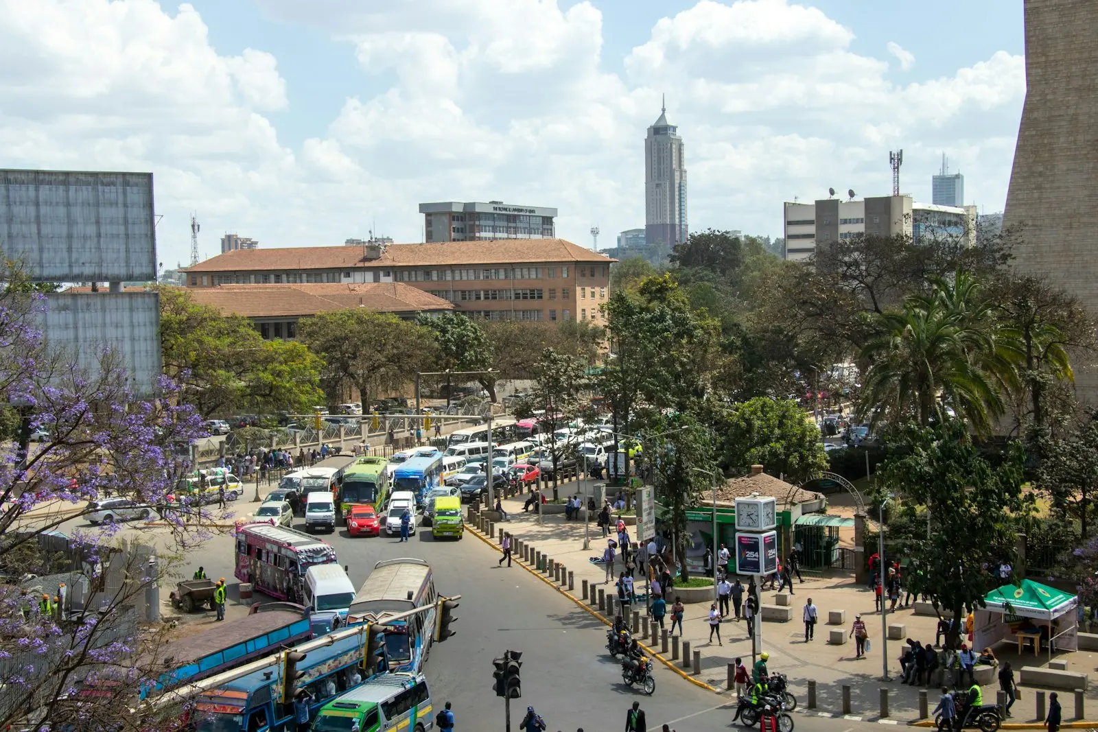 Busy street in central Nairobi with matatus, boda bodas and jacaranda trees